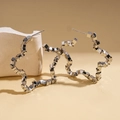 Detailed view of silver geometric star earrings on a minimalist stone display stand - Stainless Steel Post - Silver