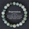 Natural green and white beaded crystal stone bracelet on a black textured background - Green Grass Silk Texture Round Beads (Depression-1)