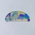 Detail shot of a semi-circular marble pattern acetate hair comb in vibrant mixed colors - Blue and Purple