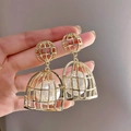 Golden double cage earrings with white pearls, held by a model for elegant fashion display - 71# Silver Needle-Gold (Birdcage)