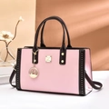 Dettaglio borsa in pelle rosa e marrone con borchie dorate e ciondolo a cigno - Rosa