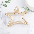 Golden hollow star-shaped metal hair claw clip displayed on a marble surface - Five-Pointed Star Gold H6411