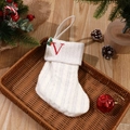 White knitted Christmas stocking with red embroidered letter V and green berry accents - Letter V
