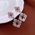 Close-up of silver floral earrings with red rectangular stone and zircon on white plate - Silver (Silver Pin)