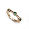 Macro view of adjustable gold ring with three green gemstones and white zircon accents - Multi-Round Stone Green