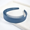Detail view of a dark blue non-slip wide headband with inner teeth on a beige velvet tray - Lacquer Blue Wide Teeth