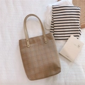 Détail du sac cabas vintage en coton à carreaux marron avec anses en cuir sur lit - Carreaux Jaune Terre