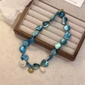 Handmade beaded necklace with blue iridescent shells and golden scallop charm - Blue
