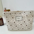 Beige corduroy makeup bag with brown floral patterns and Time To Party label - White Flower