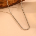 Primer plano de collar de cadena de bolas de acero inoxidable sobre un fondo de madera - Collar de Cuentas Redondas Color Acero (O103) / 40+5cm/Cuenta de 3mm