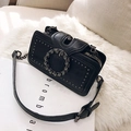 Black studded crossbody bag featuring a round rhinestone buckle and adjustable leather strap - Black