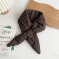 Close-up of brown quilted down scarf with cross strap design and brand label detail - Brown