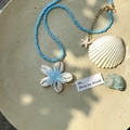 Vue détaillée du collier de perles bleues avec fleur en coquillage et étoile de mer - Fleur de Coquillage Bleue