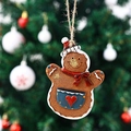 Detailed view of gingerbread man resin ornament hanging on a Christmas tree branch - Apron Style