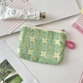 Flaches Reißverschlussetui mit grünem Blumenmuster und rosa Schlaufe auf dem Tisch - Grüner Lotus