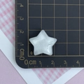 Detailed view of a 2.5cm white glitter star resin accessory on a black measuring mat - Glitter White Star