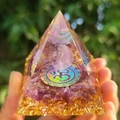 Orgone pyramid with amethyst stones and golden OM symbol held in hand outdoors - 6cm / A26-Amethyst OM Symbol Clear Ball