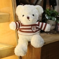 Oso de peluche blanco con suéter de rayas marrones en estante de madera y fondo verde - Oso de Peluche Blanco (Suéter de Rayas Rojas)