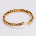 Gedetailleerde macro-opname van de gouden gevlochten textuur en afwerking van de armband - Goud