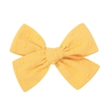 Gros plan d'un nœud papillon jaune pour cheveux avec broderie pompon et tissu texturé - Broderie à pois jaune vif