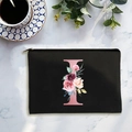 Black canvas cosmetic bag with pink letter I and floral print on marble background - Letter I