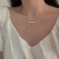Elegante collar dorado con perlas blancas usado por una modelo en un estilo minimalista - Estilo de Empalme de Perlas