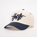 Detail shot of navy HUSTLE 3D embroidery on a cream and navy blue baseball cap - One Size / Cream/Navy Blue