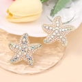 Elegant gold starfish earrings with rhinestones and pearls on a ripple glass tray - White Full Rhinestone