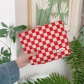 Hand holding a red and white checkered corduroy makeup bag in a bright lifestyle room - Red Beige Plaid