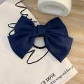 Elegant navy blue satin bow hair clip placed on a beige linen bag on wooden desk - Hair Tie / Navy Blue