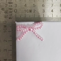 Noeud en perles roses d'environ 3,5 cm de large présenté avec une règle en acier - Nœud en perle rose clair