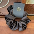 Elegant black satin scrunchie with lace trim and glossy texture on a wooden background - Rose Satin Black