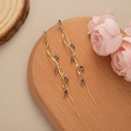 Detail of long gold tassel earrings with purple crystals on a rustic wooden tray - Gold - Purple Zirconia