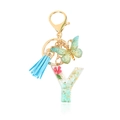 Letter Y resin keychain featuring pink dried flowers, green leaves, and a blue tassel - Letter Y
