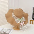 Straw sun hat with white lace ribbon, green bow and pink tulip charm on wooden stand - Single Flower Decoration - Khaki
