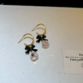 Detail of gold hoop earrings with black bow charms and faceted crystal pendants - Black Bow