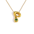 Close-up of golden letter P pendant with a green heart-shaped gemstone detail - Letter P