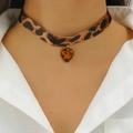 Dettaglio ravvicinato del ciondolo a cuore leopardato su un girocollo gotico nero - Pendaglio Cuore Colore Ambra Leopardato (S397)