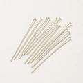 Polished silver 14K T-shape flat head pins for DIY jewelry making on beige background - Thick Silver Flat Head Pin