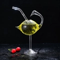 Bird-shaped cocktail glass with integrated straw and yellow drink on black base - Swan Shaped Straw Glass