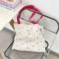 Detail van de bloemen canvas tas met roze hengsels en berenprint op een stoel - Sneeuwvlokbeer