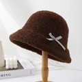 Elegant women's brown plush winter bucket hat with bow detail on wooden stand display - Coffee
