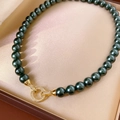 Detalle de collar de perlas verde oscuro con cierre redondo dorado y circonitas - Estilo de Perla Verde Pavo Real (WN2269) / Oro-Verde