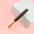 Portable mini round lip brush with brown handle and golden ferrule on blue cube - Black