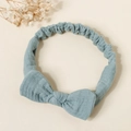 Close-up of light blue cotton bow headband with elastic strap on beige background - Bean Green