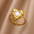 Close-up of heart-shaped iridescent stone ring with gold twisted rope band and silk background - Gold