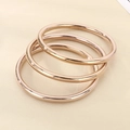 Detailed view of three stacked 18k rose gold-plated hollow bangles with mirror polish finish - Rose Gold 3-Piece Set
