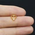 Macro shot of a tiny gold heart-shaped nose stud with opal stone on a finger tip - Hollow Heart Style (24082004049)