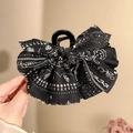 Dettaglio di un grande fermaglio per capelli con fiocco paisley nero per lo styling - Molletta per capelli nera