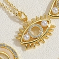 Macro shot of evil eye pendant featuring gold plating, micro-pave crystals and pearl details - Eye Shape Evil Eye XL2440-5